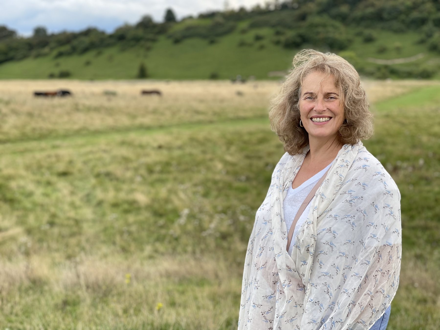 Helen Goldward, Shiatsu practitioner, standing in a meadow